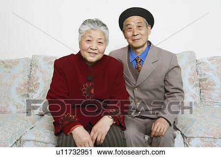 Portrait of a senior couple sitting on a couch smiling View Large Photo Image Stock Image - Portrait of a senior couple sitting on a couch smiling. Fotosearch