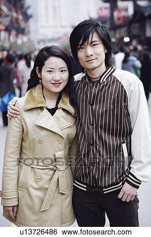 Portrait of a young couple standing together smiling View Large Photo Image Stock Photograph - Portrait of a young couple standing together smiling. Fotosearch