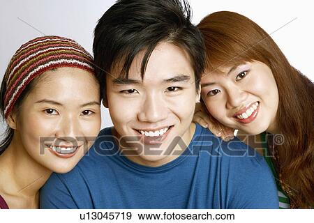 Portrait of a young man and two young women posing and smiling View Large Photo Image Stock Photo - Portrait of a young man and two young women posing and smiling. Fotosearch