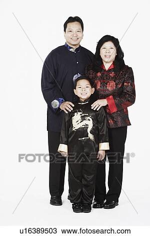 Stock Image - Portrait of parents standing together with their son smiling. Fotosearch