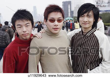 Portrait of three young men standing in the market View Large Photo Image Stock Image - Portrait of three young men standing in the market. Fotosearch
