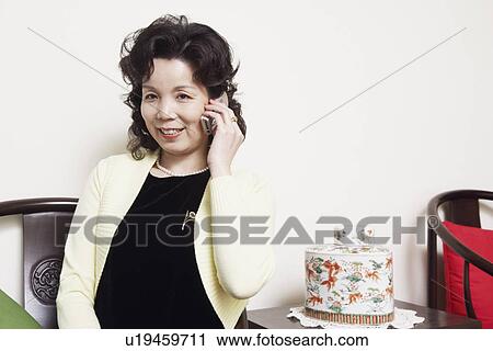 Businesswoman talking on a mobile phone smiling View Large Photo Image Stock Image - Businesswoman talking on a mobile phone smiling. Fotosearch