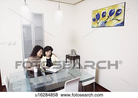 High angle view of two mature women using a laptop smiling View Large Photo Image Stock Photo - High angle view of two mature women using a laptop smiling. Fotosearch