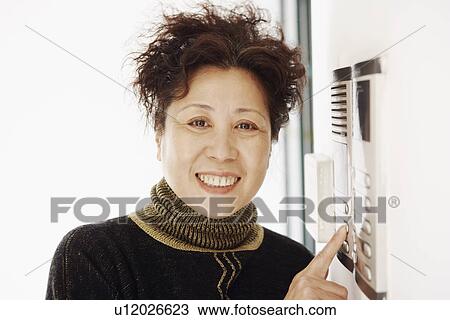 Portrait of a mature woman near an intercom View Large Photo Image Stock Image - Portrait of a mature woman near an intercom. Fotosearch