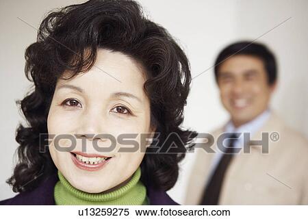 Portrait of a mature woman smiling with a mature man behind her View Large Photo Image Stock Photography - Portrait of a mature woman smiling with a mature man behind her. Fotosearch