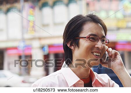 Close-up of a mid adult man talking on a mobile phone and smiling View Large Photo Image Stock Image - Close-up of a mid adult man talking on a mobile phone and smiling. Fotosearch