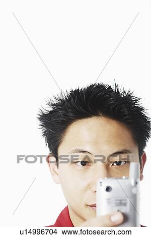 Picture - Close-up of a young man holding a mobile phone. Fotosearch