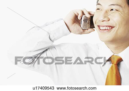 Close-up of a young man talking on a mobile phone View Large Photo Image Stock Image - Close-up of a young man talking on a mobile phone. Fotosearch