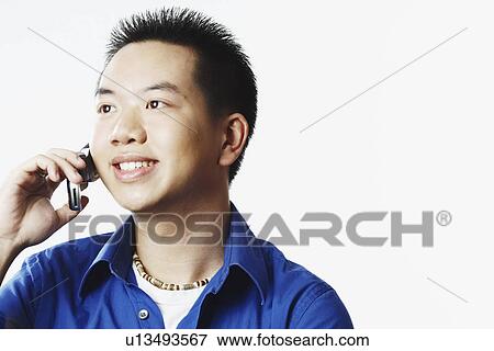 Stock Photo - Close-up of a young man talking on a mobile phone. Fotosearch