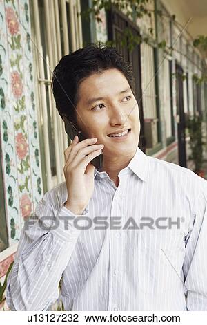 Close-up of a young woman talking on a mobile phone View Large Photo Image Stock Image - Close-up of a young woman talking on a mobile phone. Fotosearch