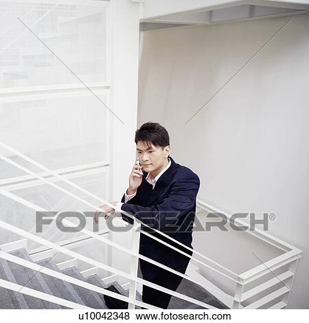 Stock Photo - High angle view of a businessman talking on a mobile phone. Fotosearch
