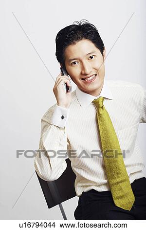 Picture - Portrait of a businessman talking on a mobile phone and smiling. Fotosearch