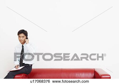 Portrait of a businessman talking on a mobile phone View Large Photo Image Stock Photograph - Portrait of a businessman talking on a mobile phone. Fotosearch
