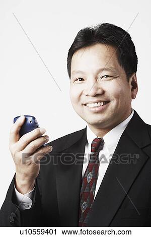 Portrait of a mid adult man holding a mobile phone smiling View Large Photo Image Stock Image - Portrait of a mid adult man holding a mobile phone smiling. Fotosearch