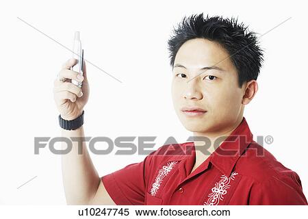 Stock Photography - Portrait of a young man holding a mobile phone. Fotosearch