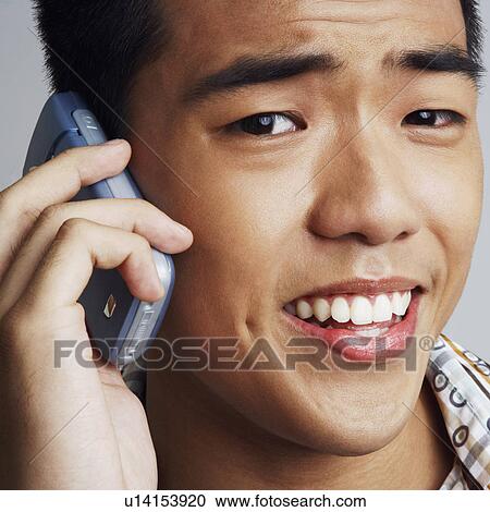 Stock Image - Portrait of a young man talking on a mobile phone. Fotosearch