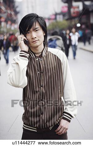 Stock Photo - Portrait of a young man using a mobile phone. Fotosearch