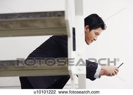 Side profile of a businessman using a mobile phone View Large Photo Image Stock Image - Side profile of a businessman using a mobile phone. Fotosearch