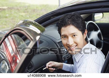 Portrait of a businessman smiling in a car View Large Photo Image Stock Photo - Portrait of a businessman smiling in a car. Fotosearch