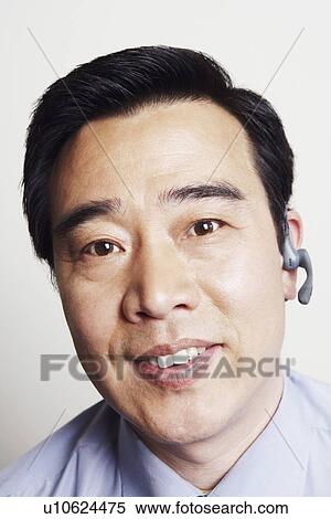 Portrait of a businessman wearing a hands free device smiling View Large Photo Image Stock Photography - Portrait of a businessman wearing a hands free device smiling. Fotosearch
