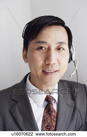 Stock Image - Portrait of a customer service representative wearing a headset smiling. Fotosearch