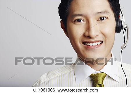 Stock Photograph - Portrait of a male customer service representative smiling. Fotosearch