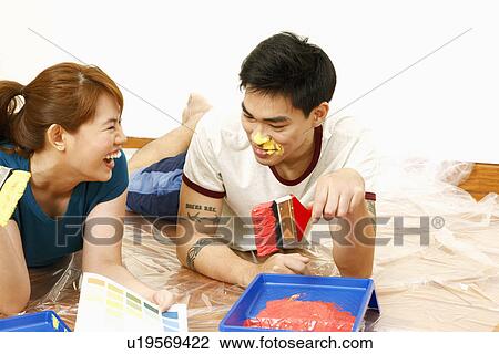 Mid adult woman and a young man holding paintbrushes and smiling View Large Photo Image Stock Image - Mid adult woman and a young man holding paintbrushes and smiling. Fotosearch