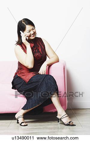 Stock Image - Mid adult woman talking on a mobile phone. Fotosearch