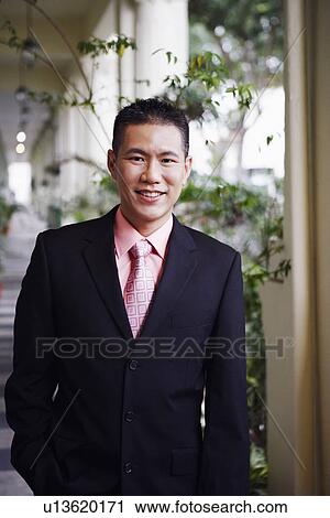 Portrait of a businessman standing in the corridor and smiling View Large Photo Image Stock Image - Portrait of a businessman standing in the corridor and smiling. Fotosearch