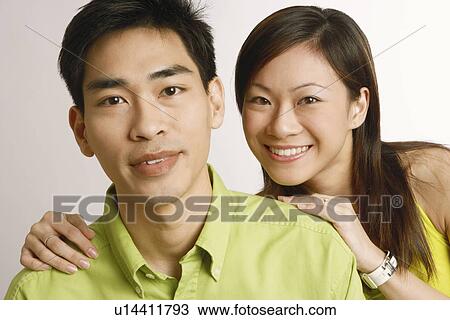 Stock Image - Portrait of a mid adult man and a young woman posing and smiling. Fotosearch
