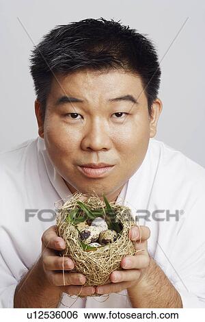 Portrait of a mid adult man holding a bird's nest View Large Photo Image Stock Photograph - Portrait of a mid adult man holding a bird's nest. Fotosearch