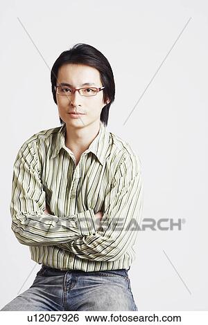 Portrait of a mid adult man sitting with his arms crossed View Large Photo Image Stock Photograph - Portrait of a mid adult man sitting with his arms crossed. Fotosearch
