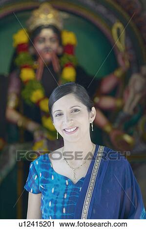 Portrait of a mid adult woman standing in front of a religious figure View Large Photo Image Stock Image - Portrait of a mid adult woman standing in front of a religious figure. Fotosearch