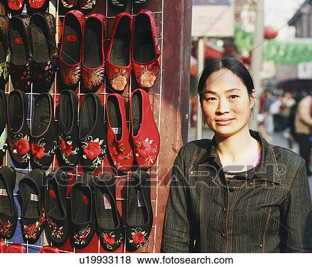Stock Photo - Portrait of a mid adult woman standing in a shoe store. Fotosearch