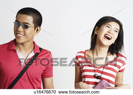 Stock Image - Close-up of a young couple listening to music. Fotosearch
