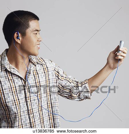 Stock Photography - Close-up of a young man wearing headphones and listening to music. Fotosearch
