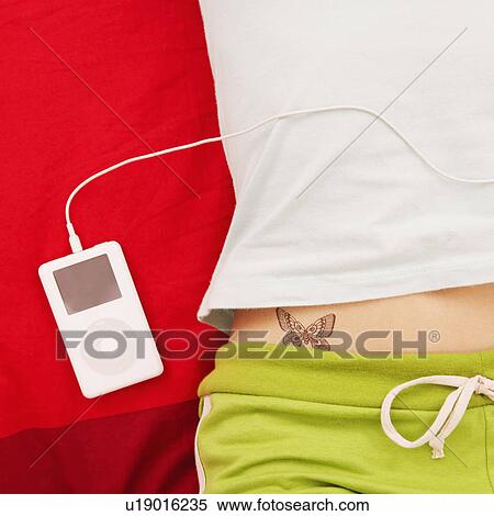 Stock Photography - Mid section view of a woman with an MP3 player. Fotosearch