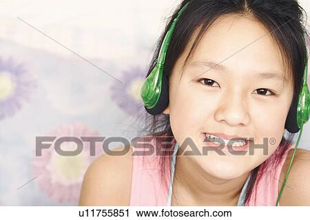 Portrait of a girl wearing headphones listening to music View Large Photo Image Stock Image - Portrait of a girl wearing headphones listening to music. Fotosearch