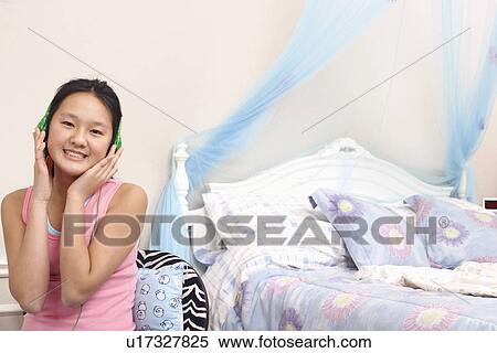 Stock Photography - Portrait of a girl wearing headphones listening to music. Fotosearch