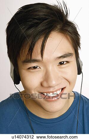Stock Image - Portrait of a young man listening to music and smiling. Fotosearch