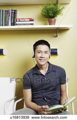 Portrait of a young man listening to music on headphones View Large Photo Image Stock Photo - Portrait of a young man listening to music on headphones. Fotosearch