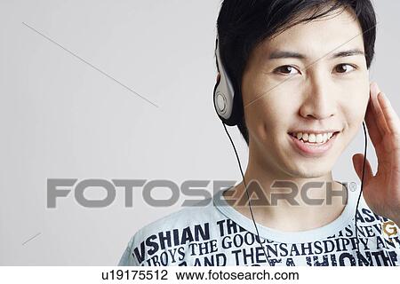Portrait of a young man wearing headphones and listening to music View Large Photo Image Stock Image - Portrait of a young man wearing headphones and listening to music. Fotosearch