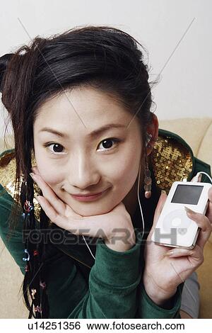 Portrait of a young woman listening to music View Large Photo Image Stock Photograph - Portrait of a young woman listening to music. Fotosearch