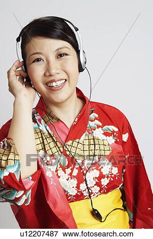 Portrait of a young woman wearing headphones and listening to music View Large Photo Image Stock Photo - Portrait of a young woman wearing headphones and listening to music. Fotosearch