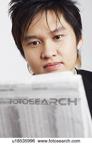 Stock Photograph - Close-up of a businessman reading a newspaper. Fotosearch
