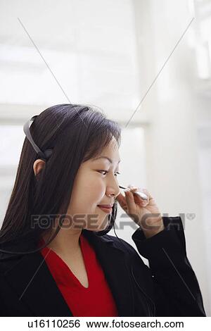 Close-up of a female customer service representative talking on a headset View Large Photo Image Stock Photograph - Close-up of a female customer service representative talking on a headset. Fotosearch