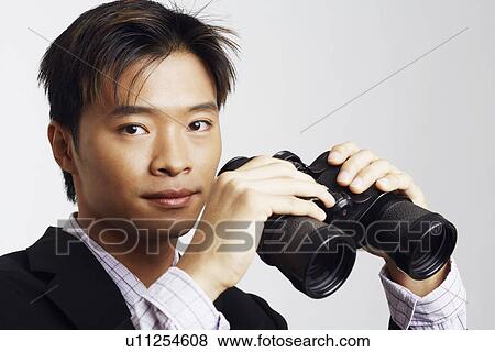 Stock Photo - Portrait of a businessman holding a pair of binoculars. Fotosearch
