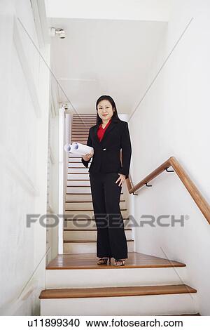 Portrait of a businesswoman carrying rolled up charts and smiling View Large Photo Image Stock Image - Portrait of a businesswoman carrying rolled up charts and smiling. Fotosearch