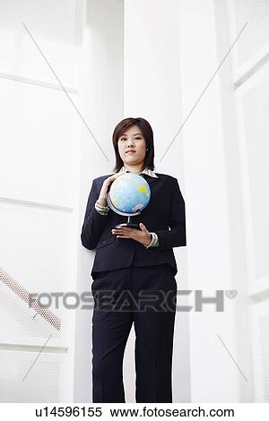 Stock Photography - Portrait of a businesswoman holding a globe. Fotosearch