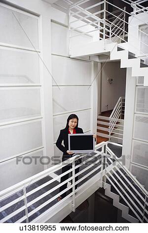 Stock Photography - Portrait of a businesswoman showing a growth chart. Fotosearch